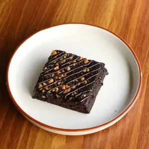Freshly baked walnut brownie with rich chocolate texture and crunchy walnuts served warm at Avaya Café