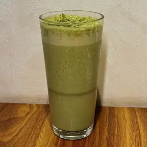Chilled banana matcha iced latte in a glass, creamy and refreshing, served at Avaya Café