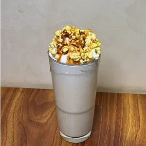 Creamy caramel popcorn shake topped with crunchy popcorn and sweet drizzle served chilled