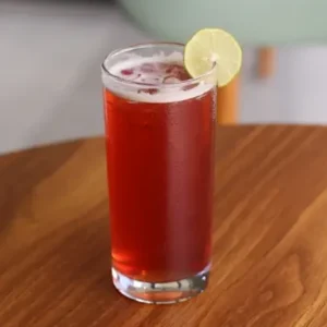 Glass of refreshing berry iced tea with mixed berries and ice cubes
