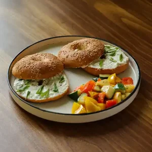 Freshly baked Spring Onion and Cream Cheese Bagel with creamy filling, served as a savory café-style treat.