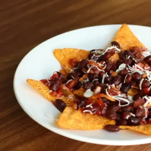 Plate of Mexican Nachos topped with cheese, jalapeños, and tangy sauce