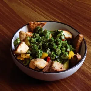 Hulk Salad with paneer and chicken, fresh greens, and zesty dressing served in a café-style bowl