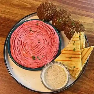 Falafel Mezze Platter with hummus, tabbouleh, and pita on a wooden board