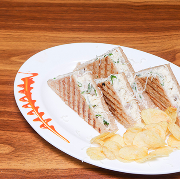Egg chicken cheese sandwich with toasted bread fried eggs and melted cheese served at Avayacafe with chips
