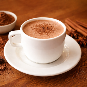 Cup of creamy hot cocoa topped with whipped cream and chocolate shavings at Avayacafe.